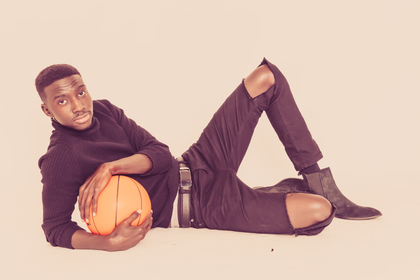 Male model purple, reclining with basketball, sport/fashion.