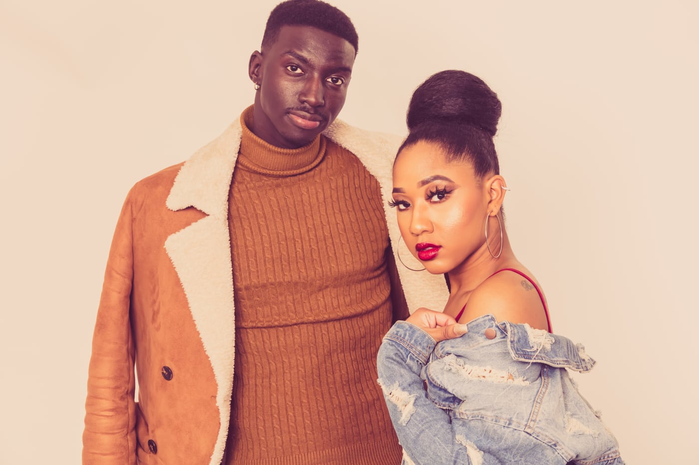 Stylish couple, orange coat, editorial fashion.