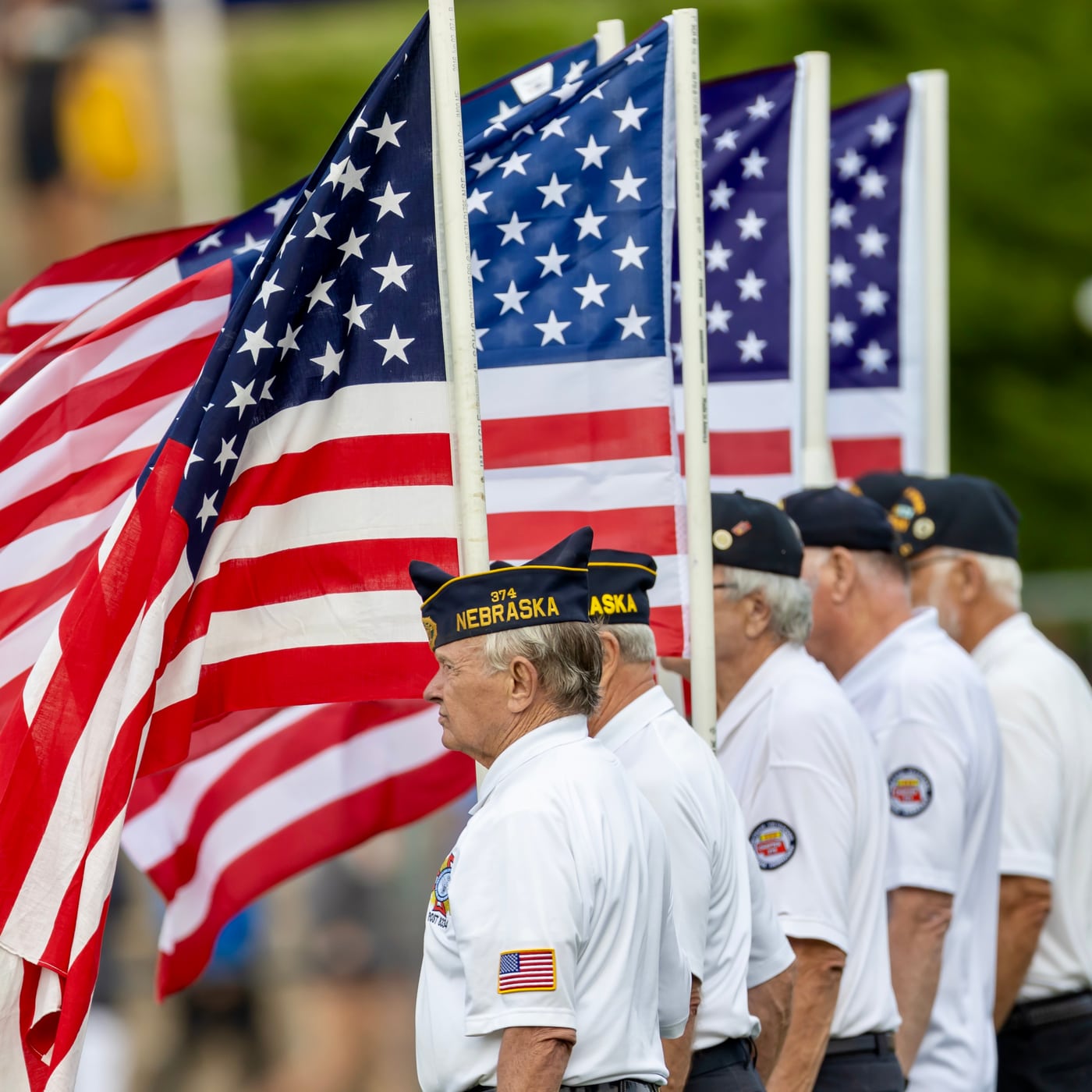 Veterans honor guard with flags, community.