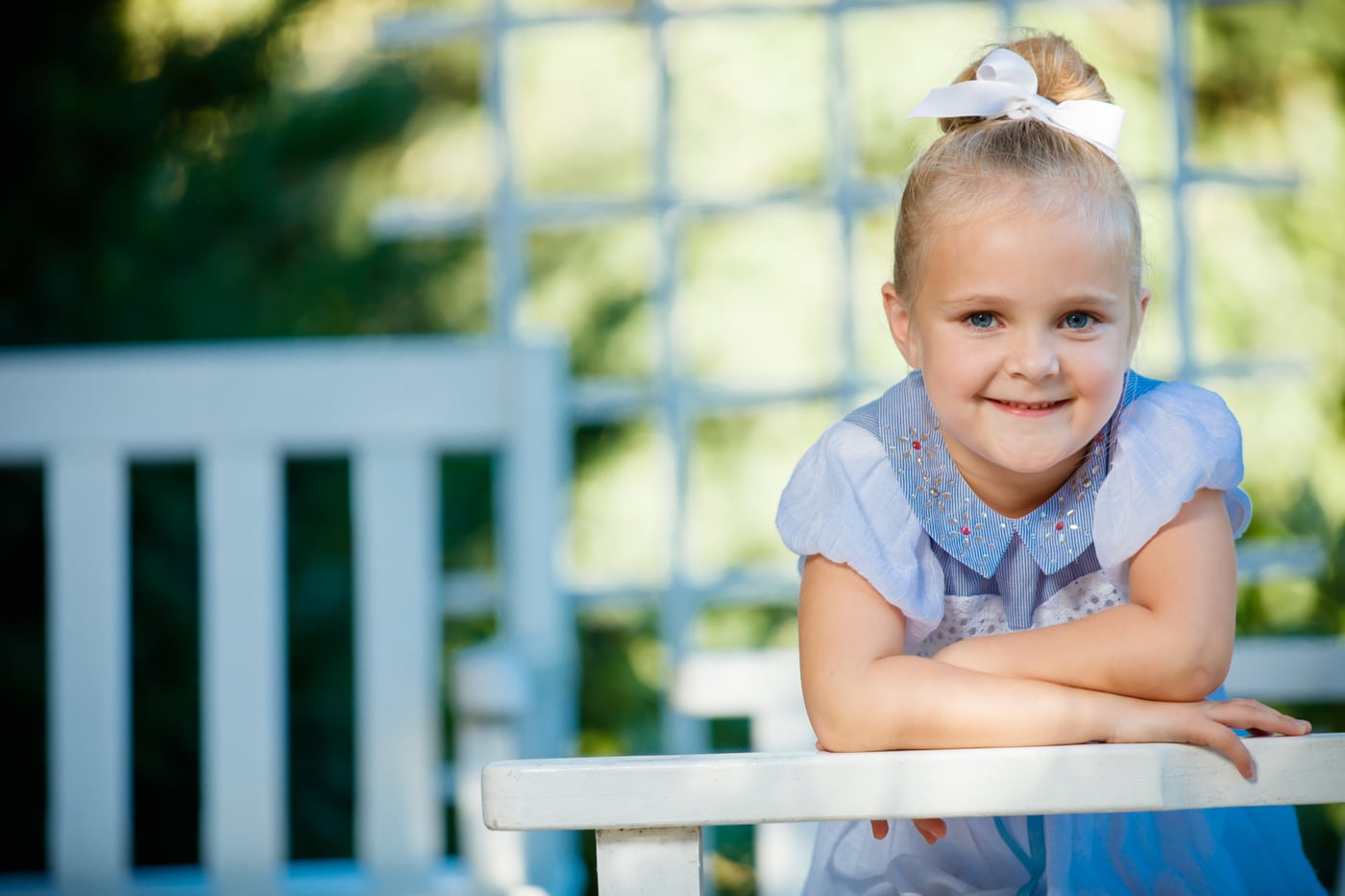 Little girl blue dress at fence, genuine smile, children.