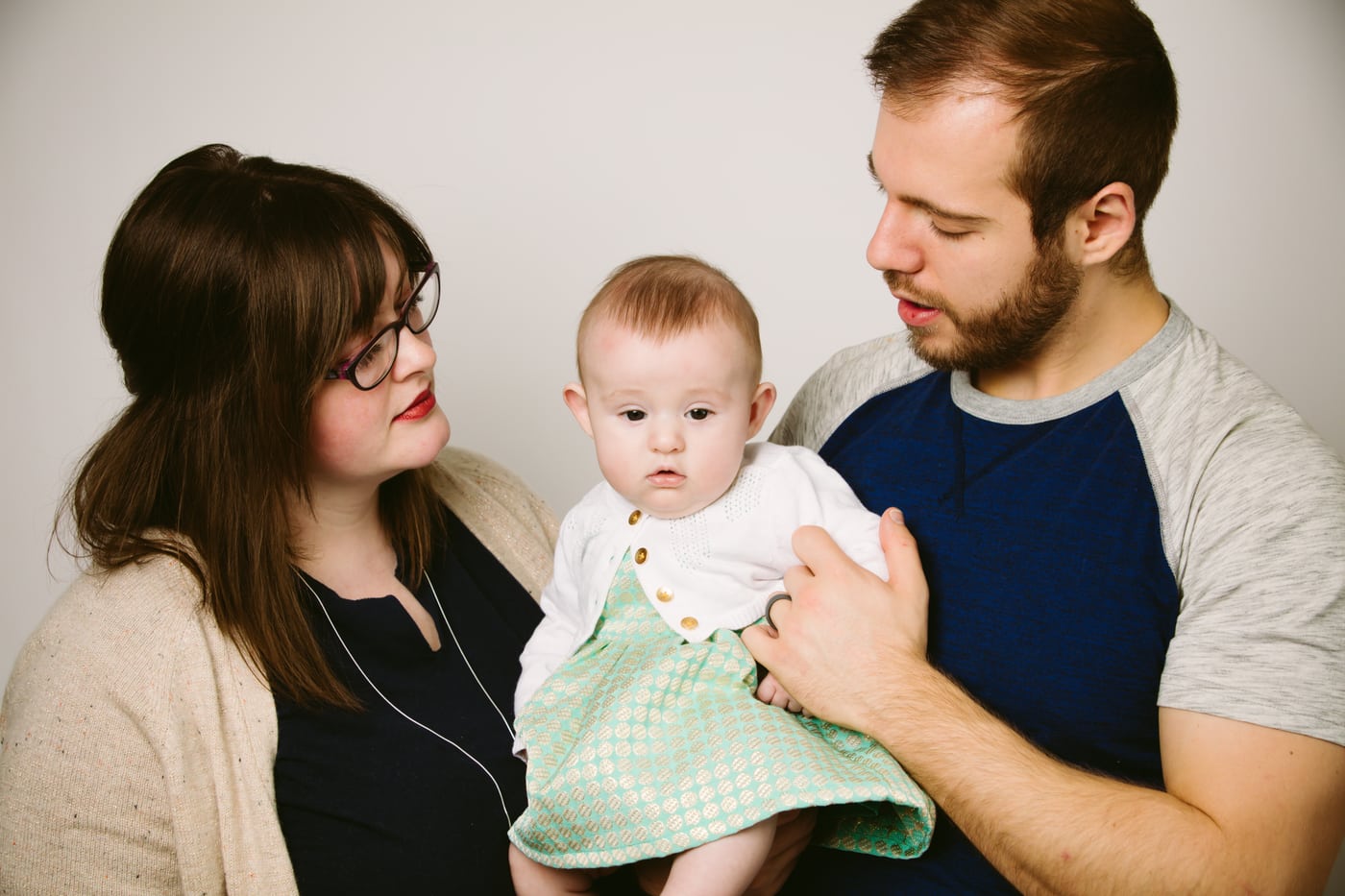 Mom, dad, baby, tender family trio.