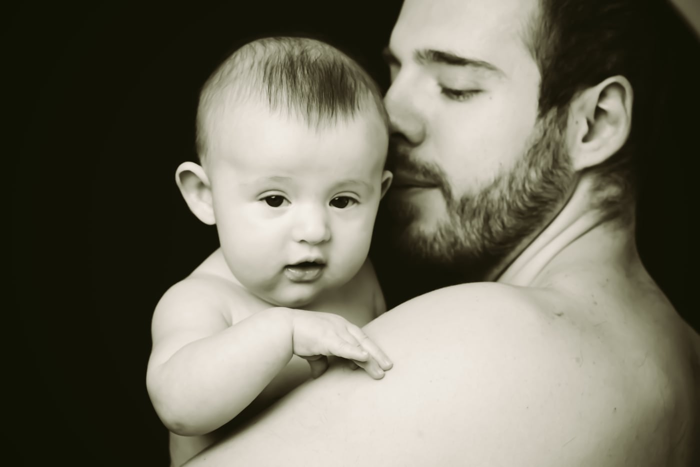 Dad kissing baby, B&W, emotional.