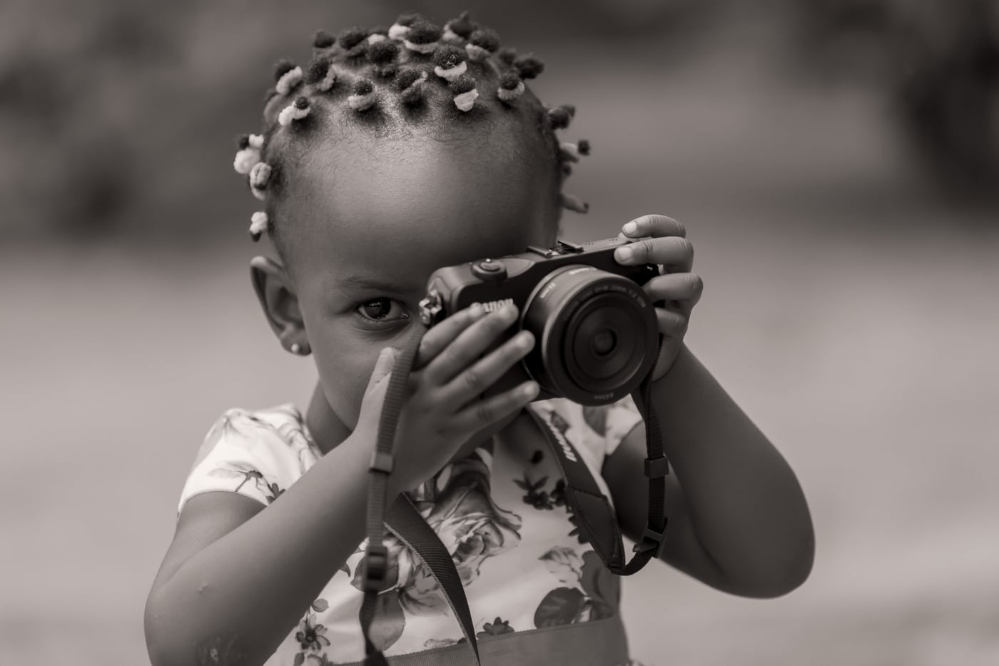 Little girl holding a camera, B&W, charming.