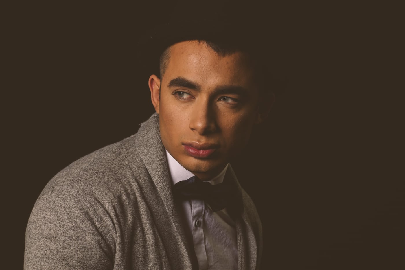 Male model gray sweater bowtie, dark, strong.