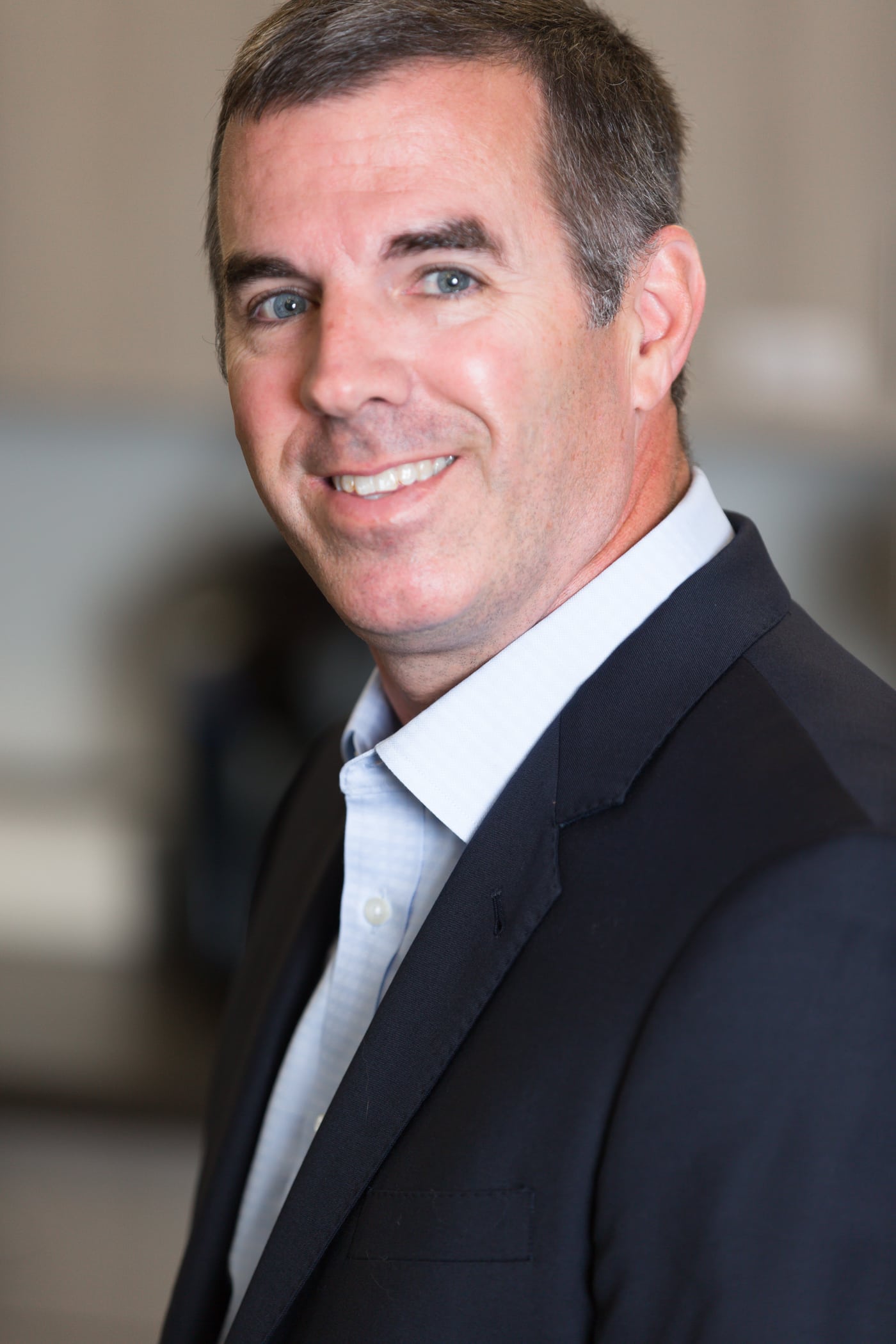 Executive man gray suit, smiling, strong headshot.