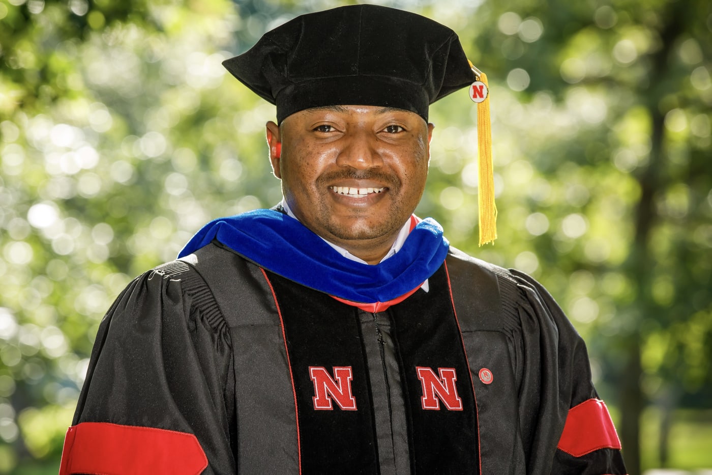 Professional doctoral portrait in academic regalia.