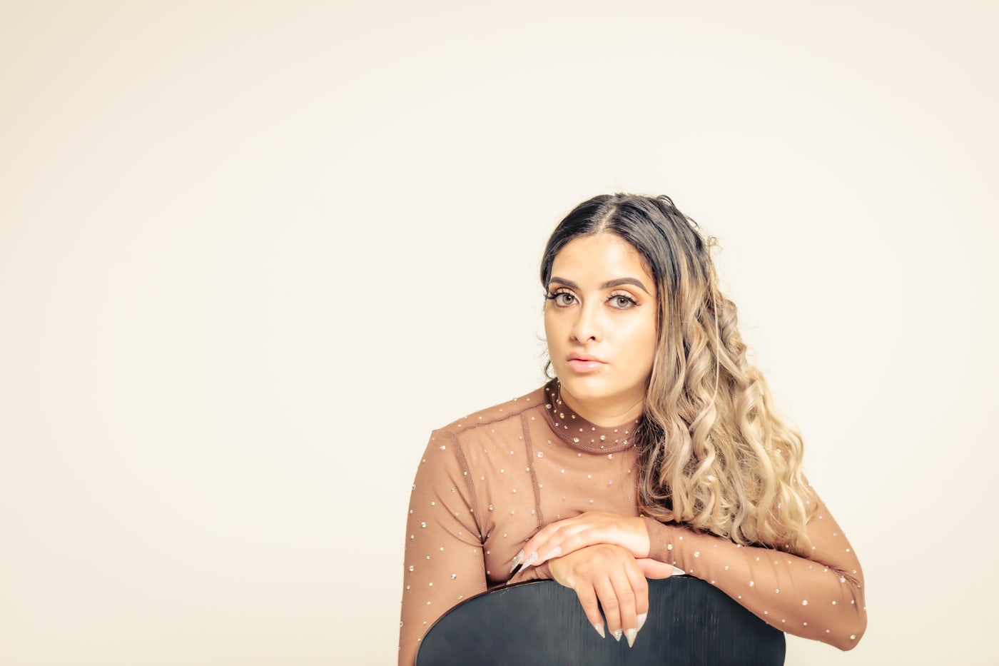 Clean studio personal-brand portrait on warm seamless background.
