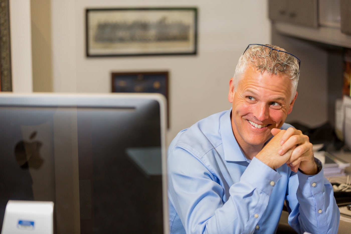 Business owner portrait at an office workstation.