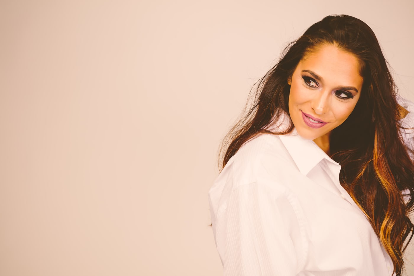 Warm studio personal-brand headshot in a white shirt.
