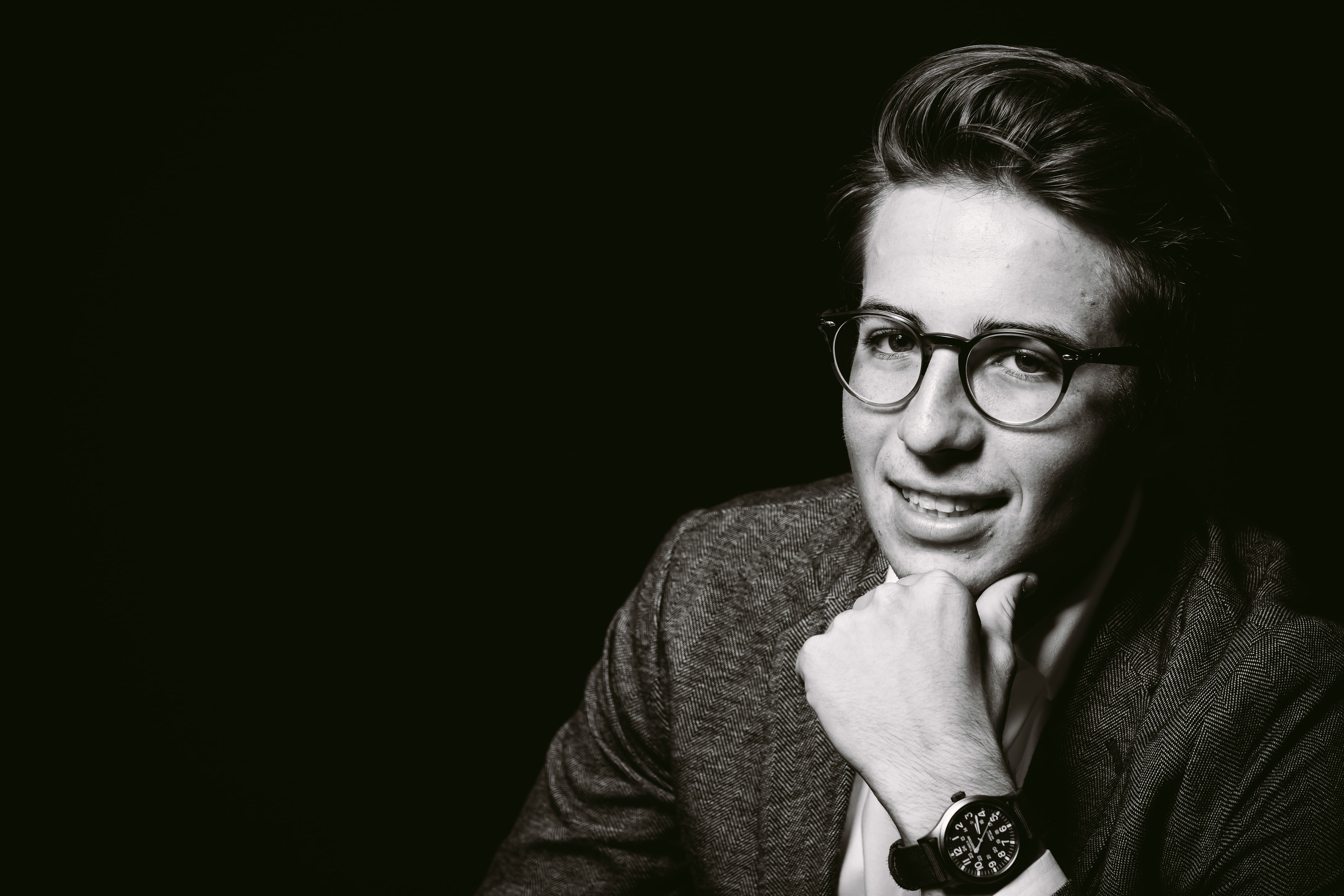 B&W senior/young man, glasses, thoughtful, editorial.