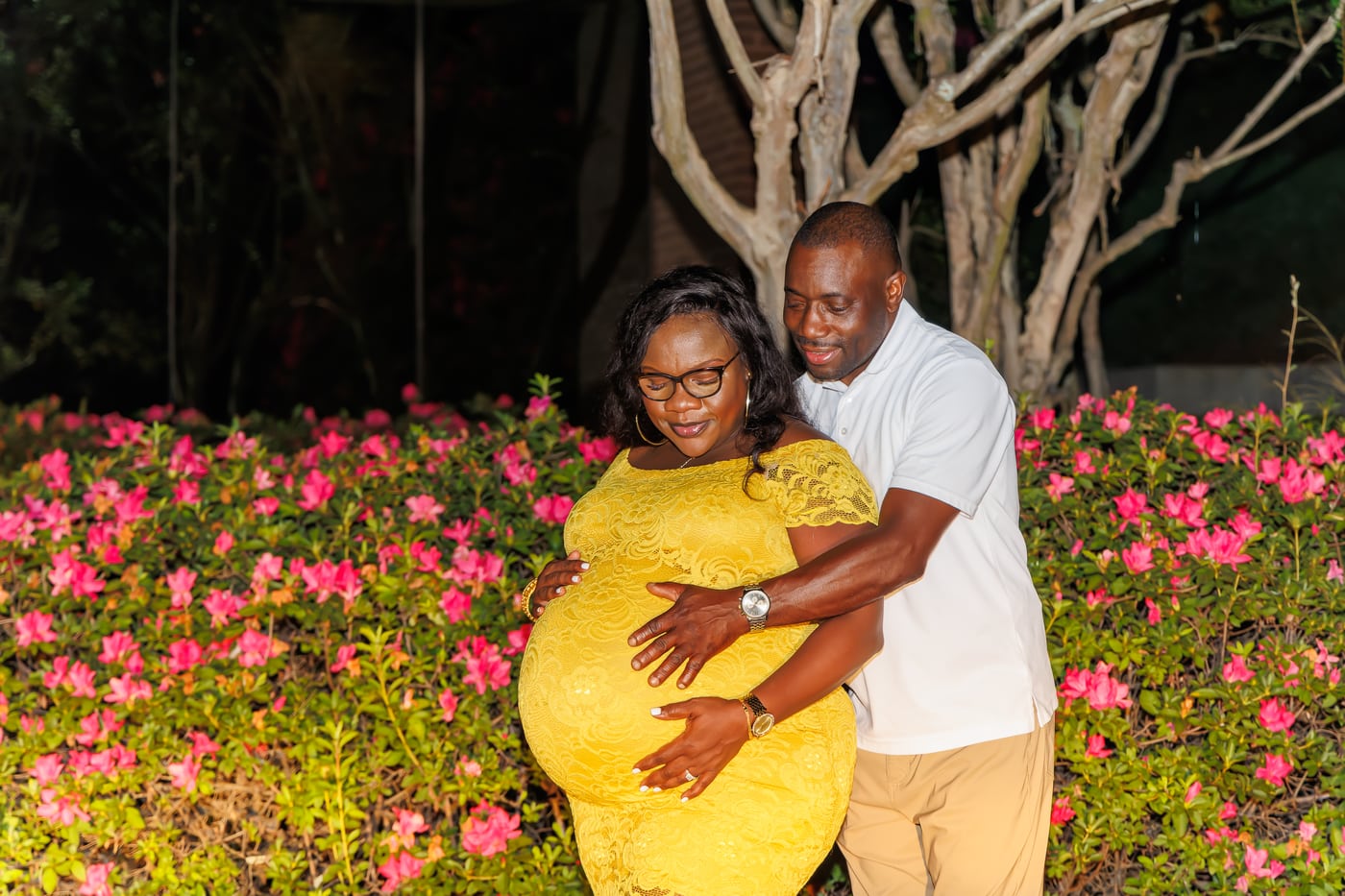 Maternity couple, garden flowers, yellow dress.