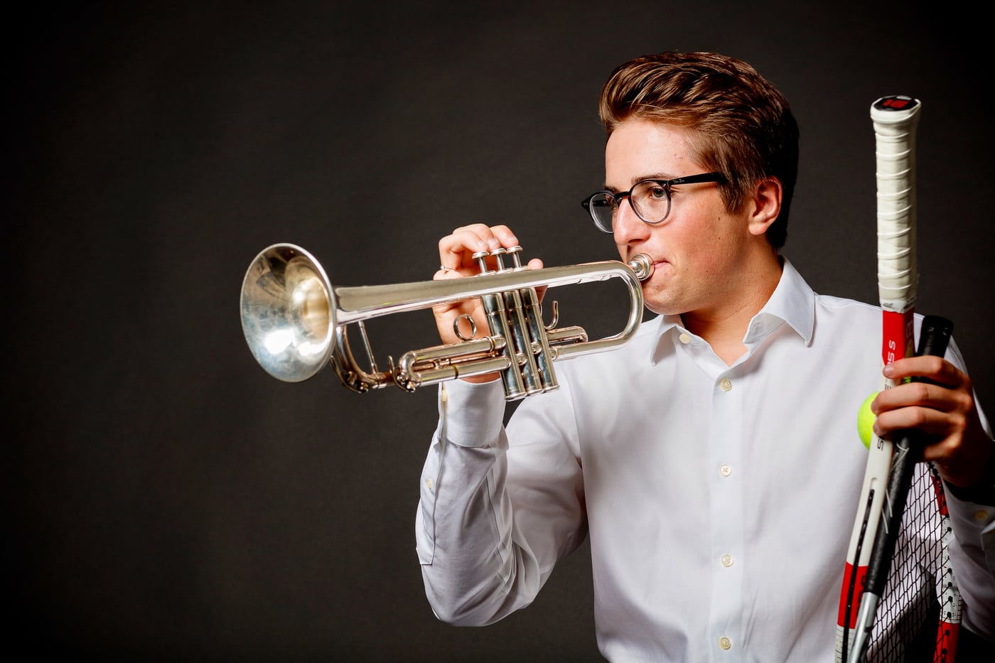 Senior with trumpet + tennis racket, music.