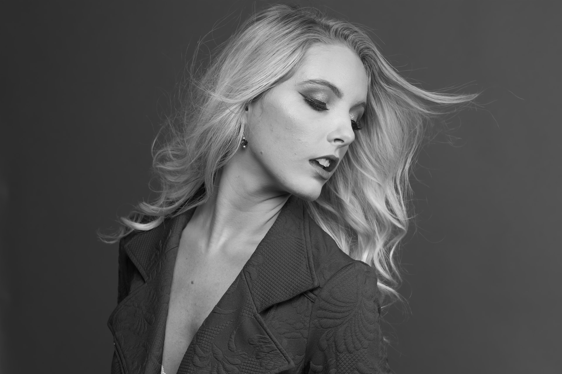 B&W windblown blonde, dramatic studio.