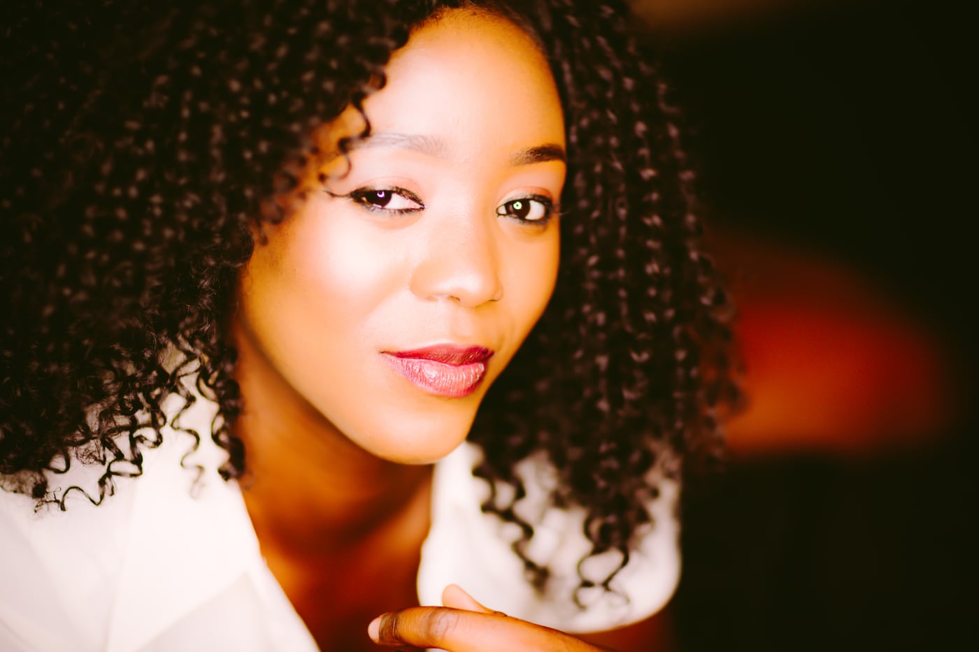 Woman curly hair close-up, warm intimate light.
