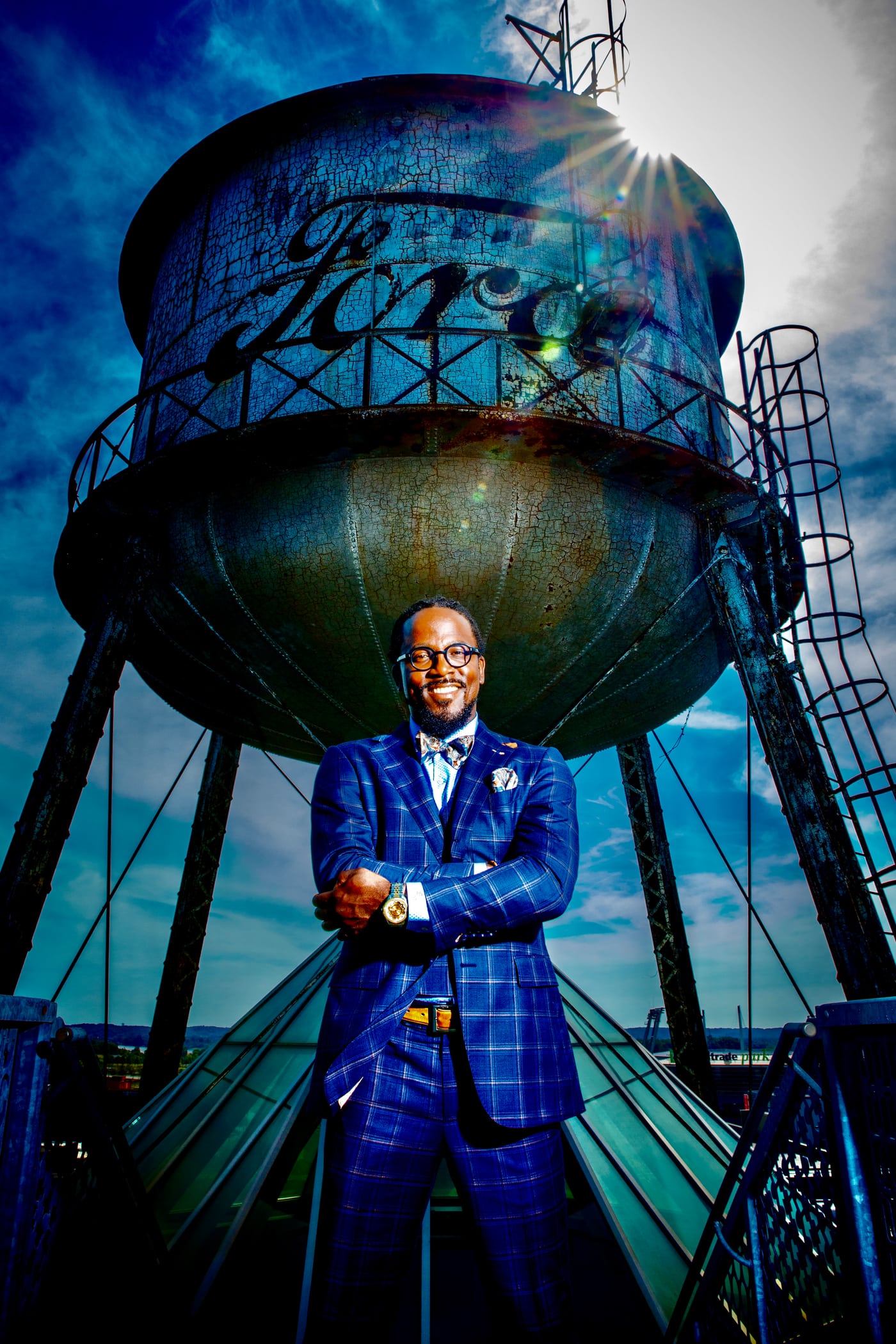 Executive at water tower, urban dramatic, commercial portrait.