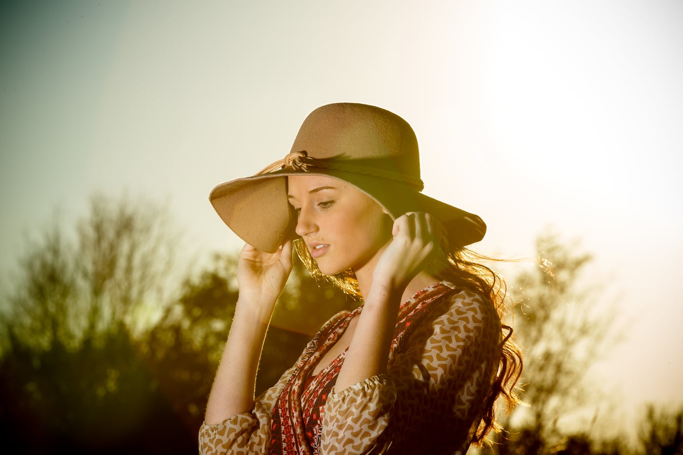 Woman floppy hat, boho, backlit golden.