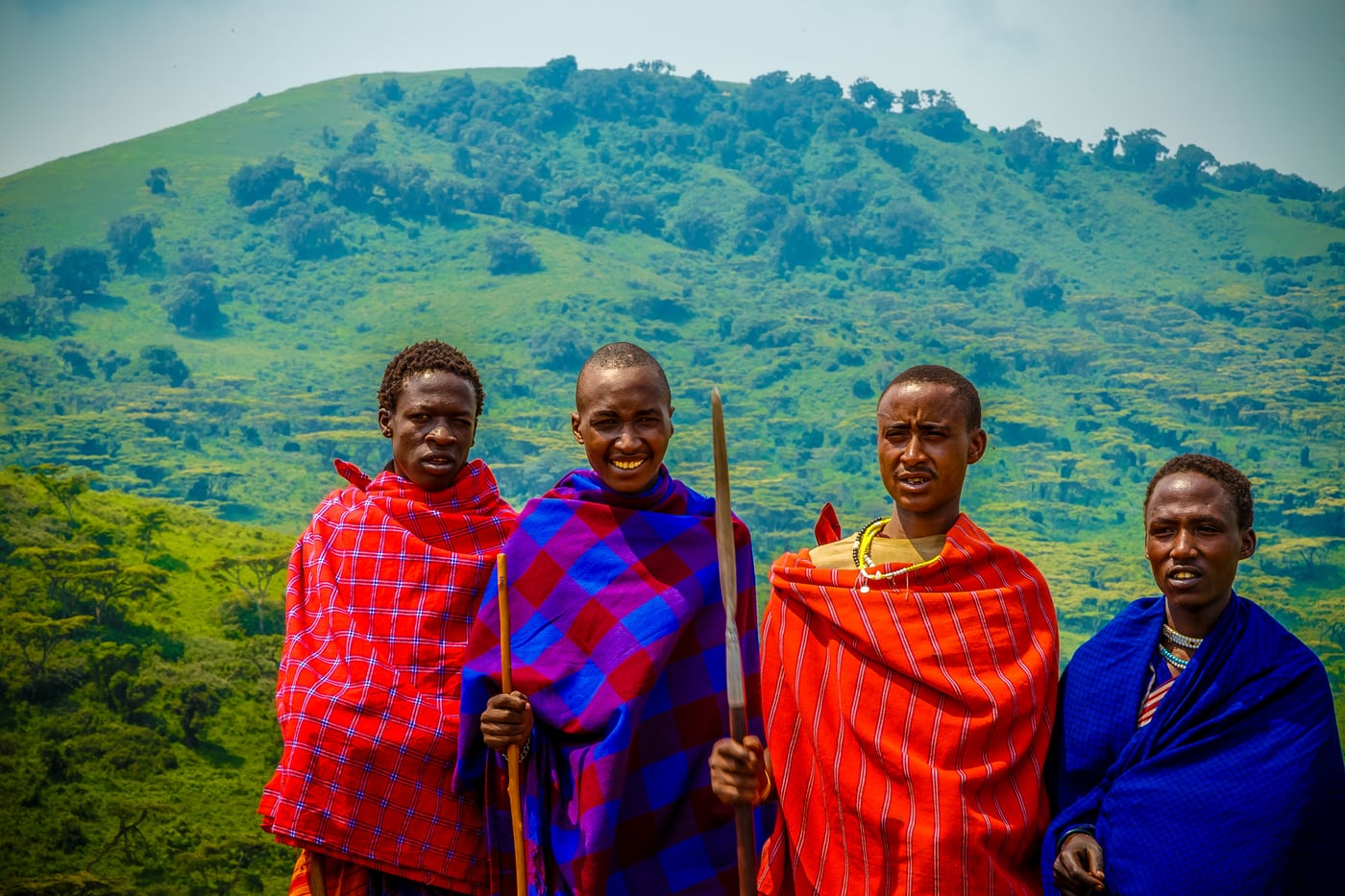 Three Maasai men in traditional dress, signature cultural.