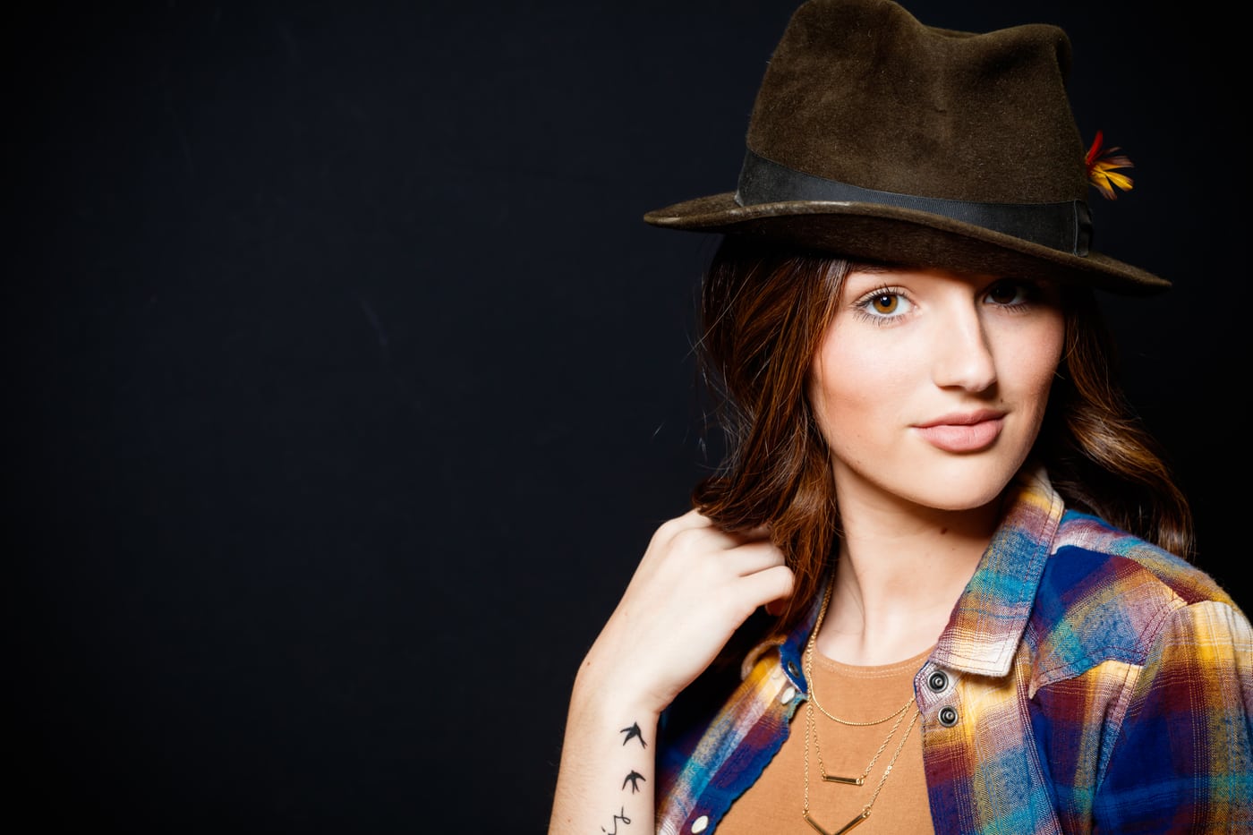 Girl in felt hat + plaid, sunflower, moody.