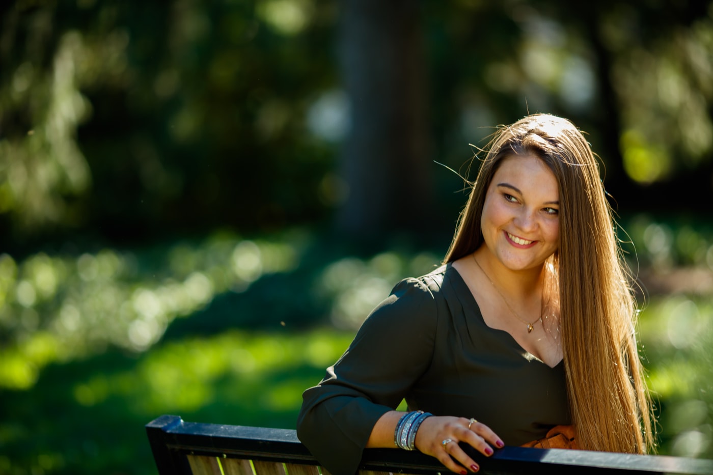 Senior portrait on green bench.