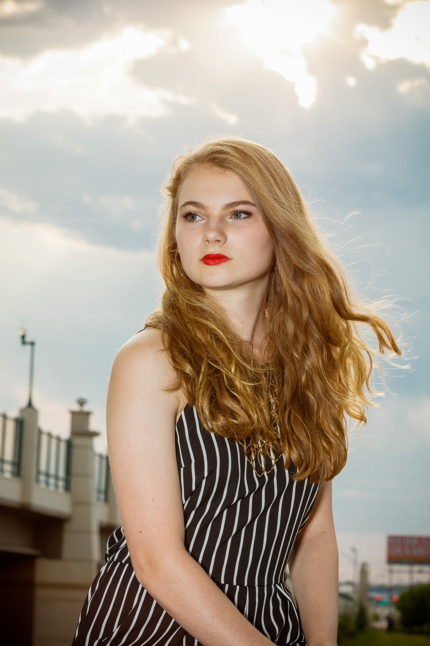 Rooftop senior portrait with open sky and strong styling.