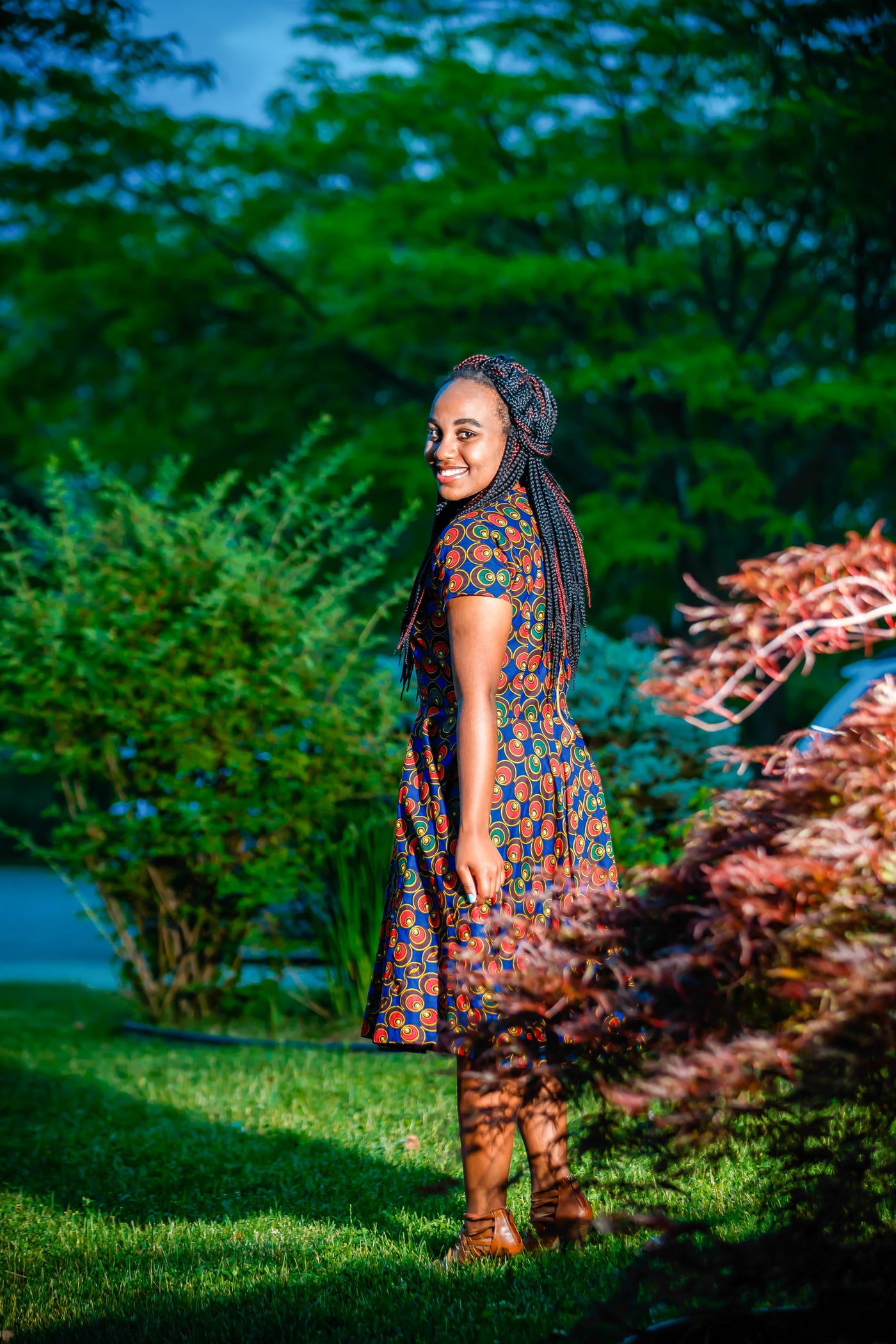Outdoor senior portrait in green garden light.