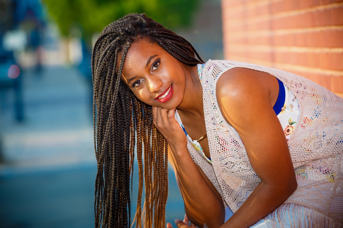 Senior portrait with polished expression and brick setting.