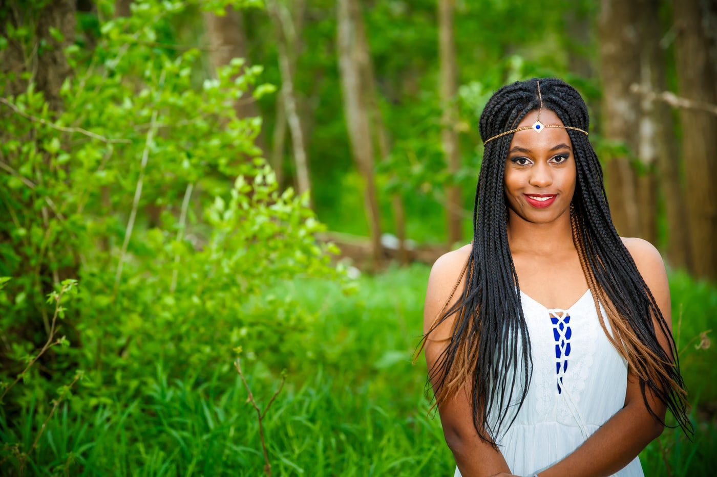 Outdoor senior portrait with soft green background.