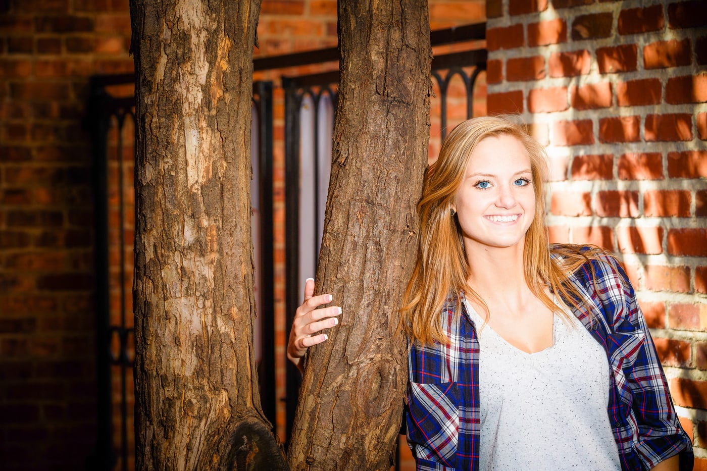 Senior portrait with brick and wood texture.