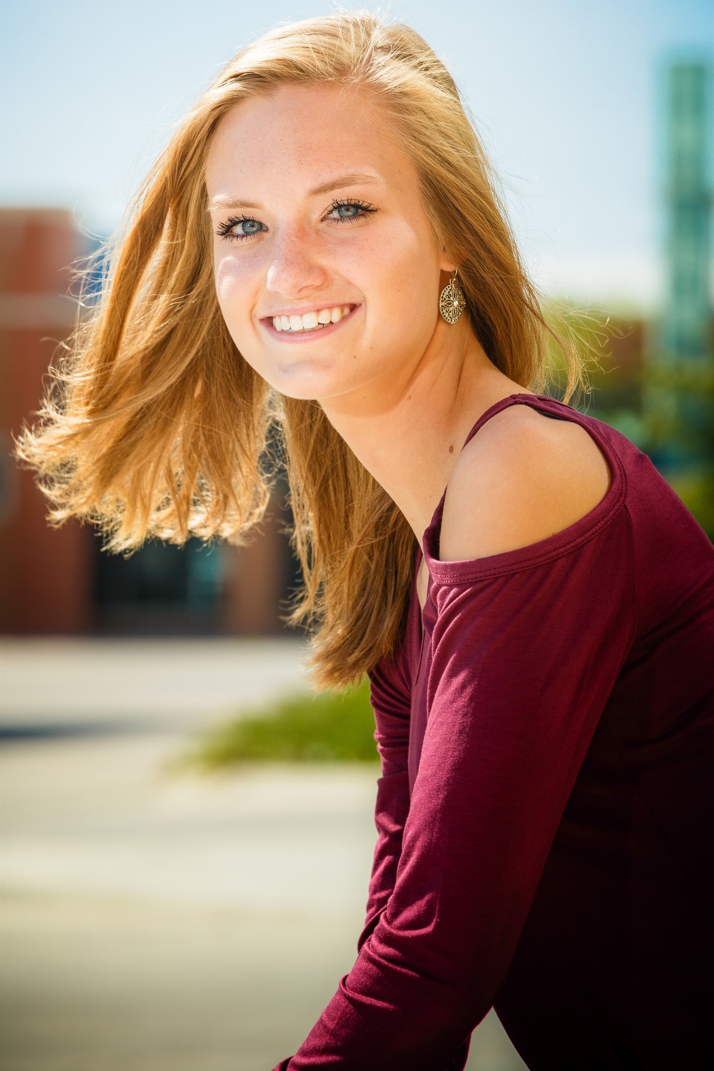 Bright outdoor senior portrait in burgundy top.