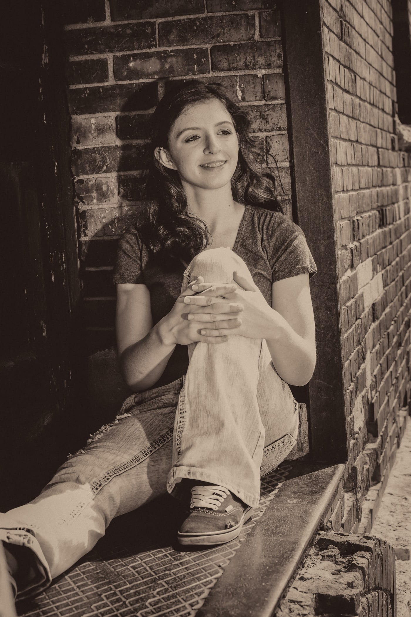 Black-and-white senior portrait in architectural setting.