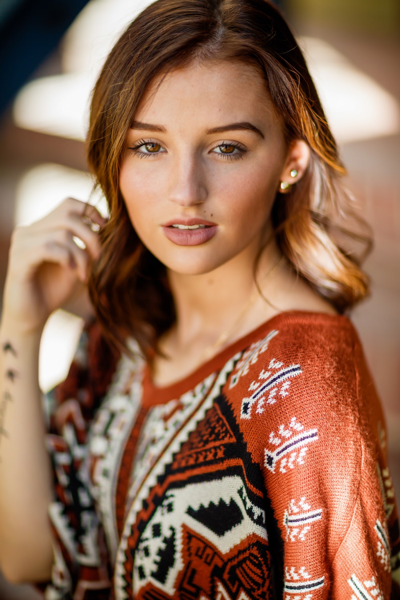 Senior portrait with direct eye contact and patterned wardrobe.