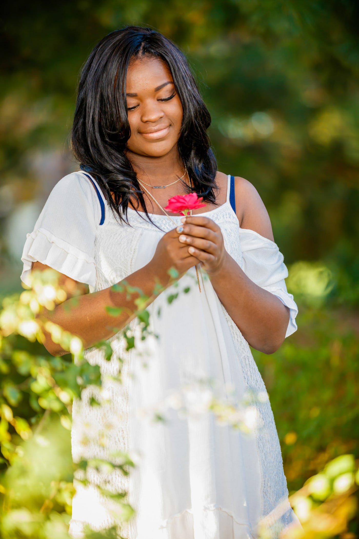Soft senior portrait with white dress and warm foliage.