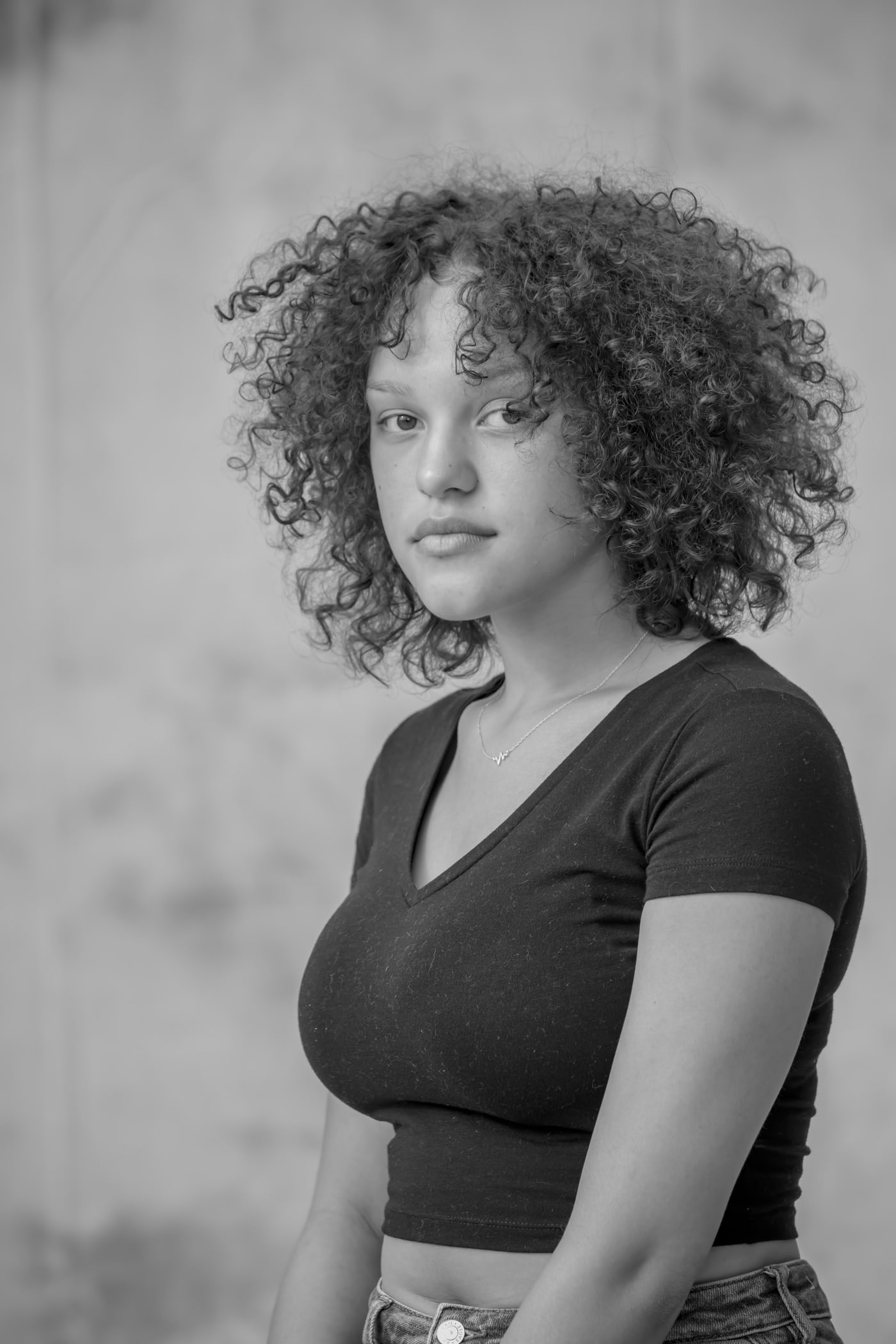 Black-and-white senior portrait with textured curls.