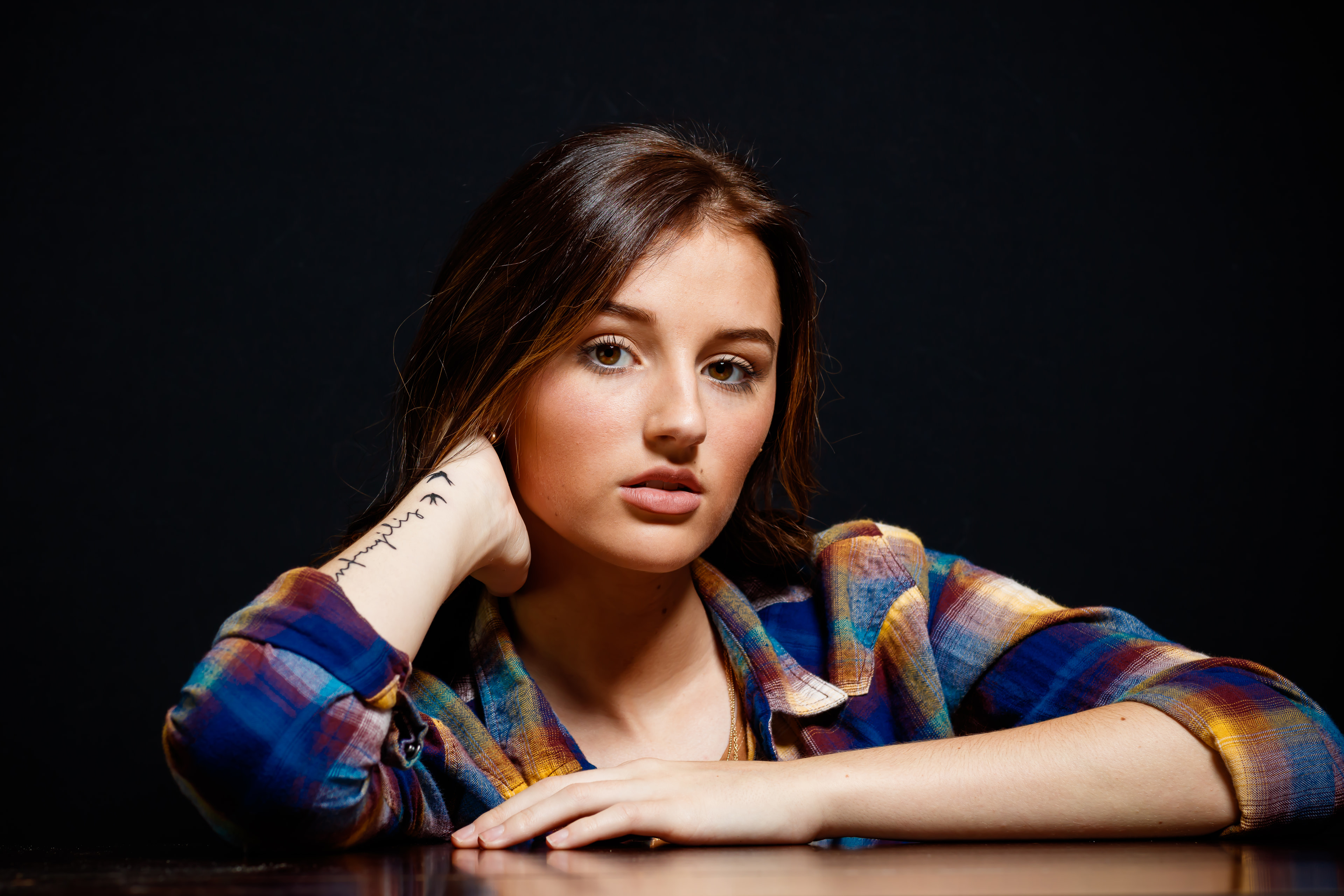 Brunette plaid, dark bg, arresting eyes, polished senior.