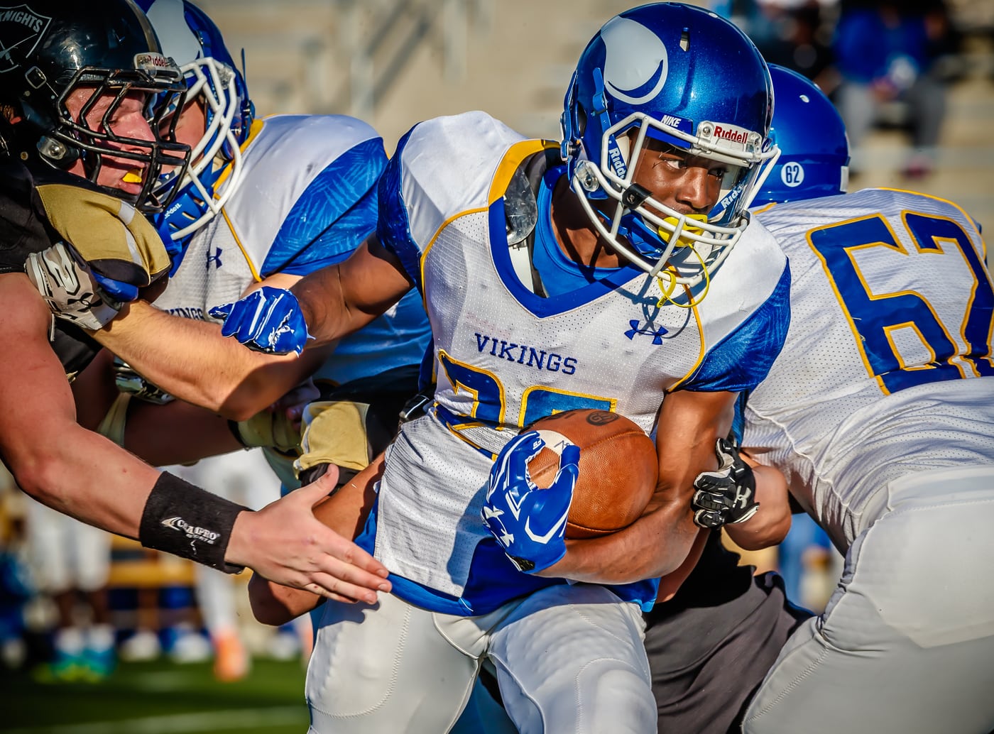 Football gang tackle #62, gritty peak action.