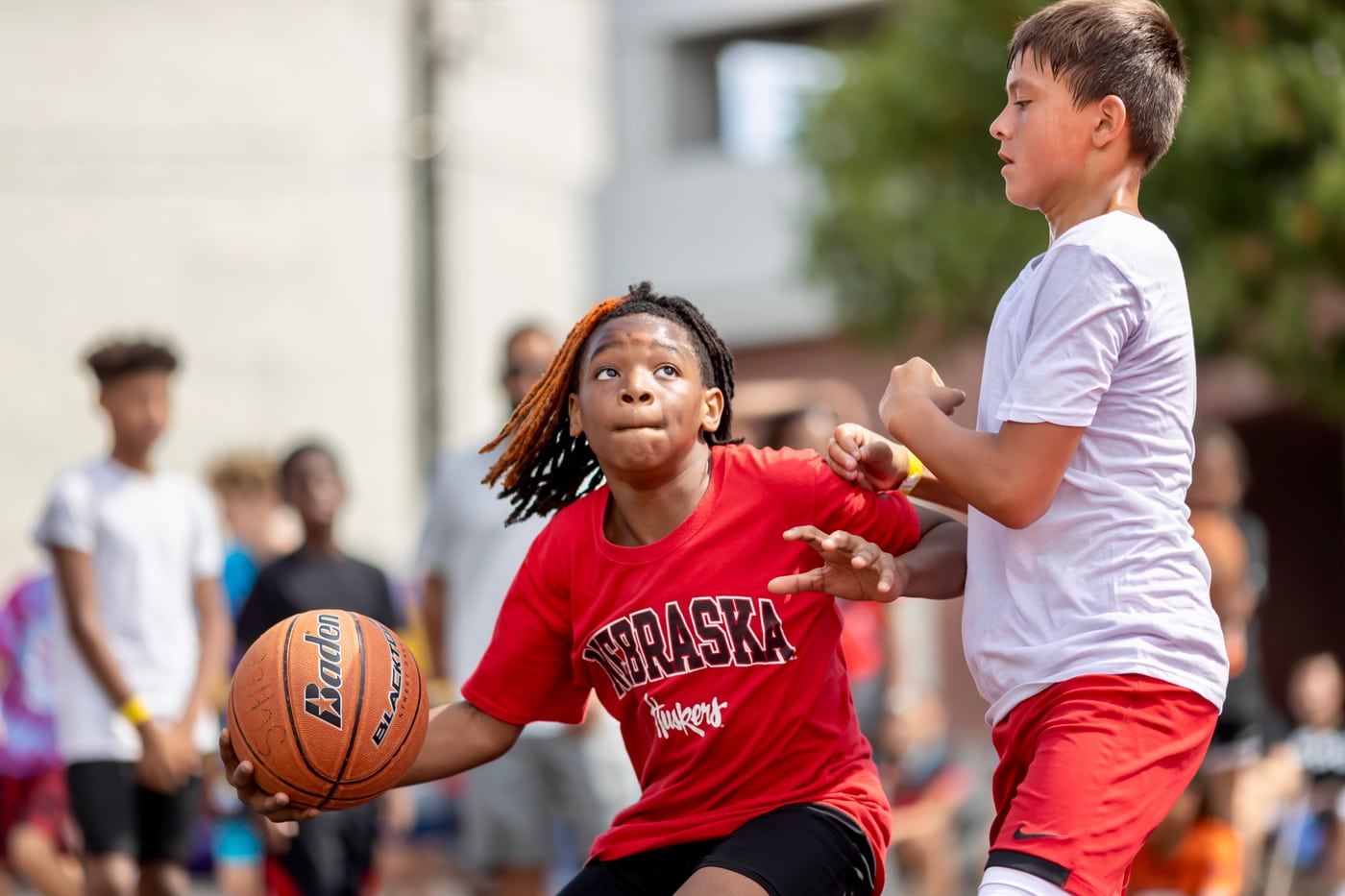 Kids basketball game, Nebraska jersey, action.