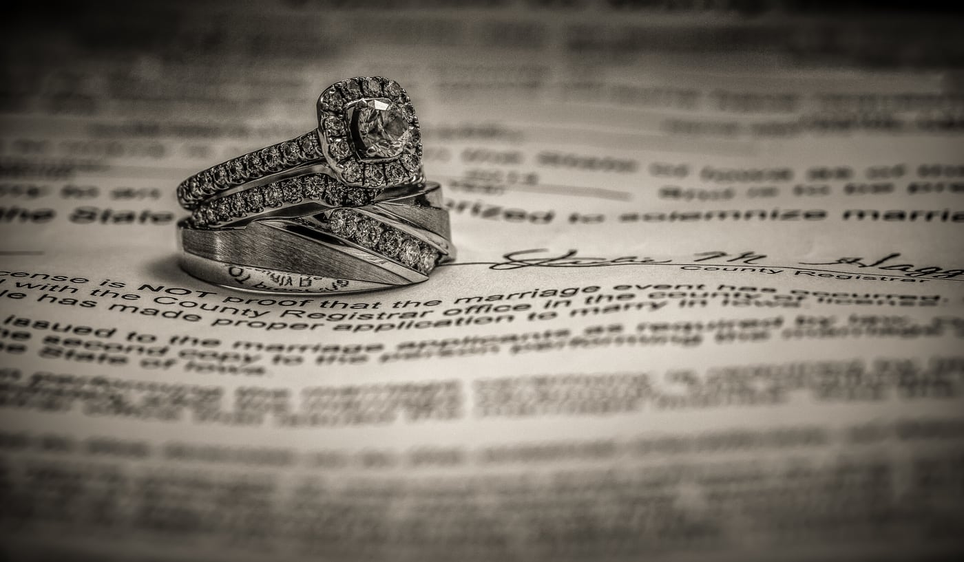 Rings on marriage certificate, elegant detail.