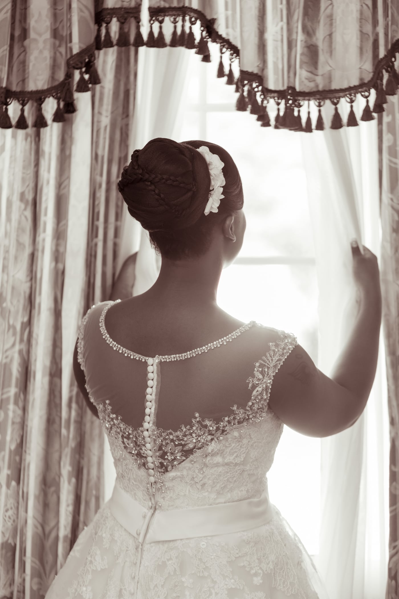 Bride at window, sepia veil, elegant.