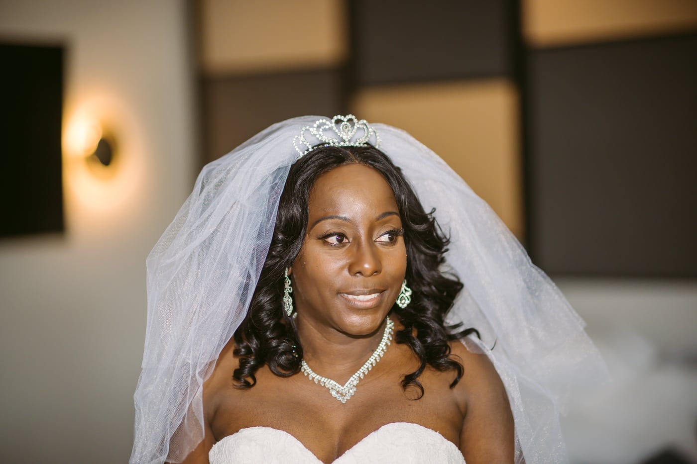 Bride tiara + veil, dark bg, radiant, bridal portrait. Photograph by Samuel Mfinanga for Mfinanga Photography + Motion.