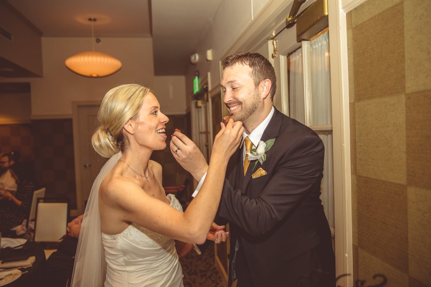 Cake feeding, playful laugh, candid.