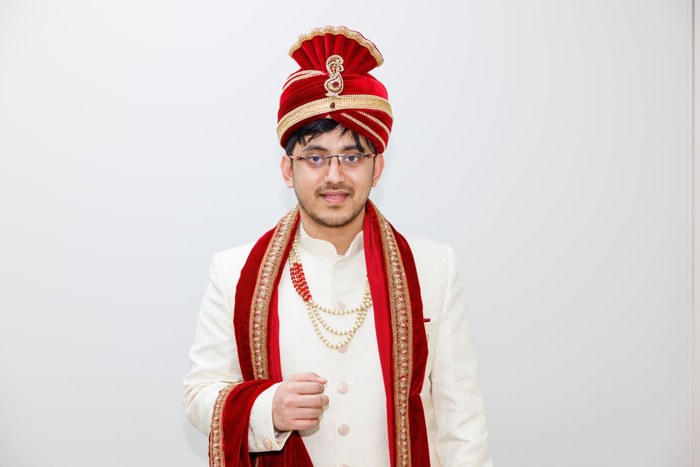 Indian groom, red turban + sherwani, cultural bridal.