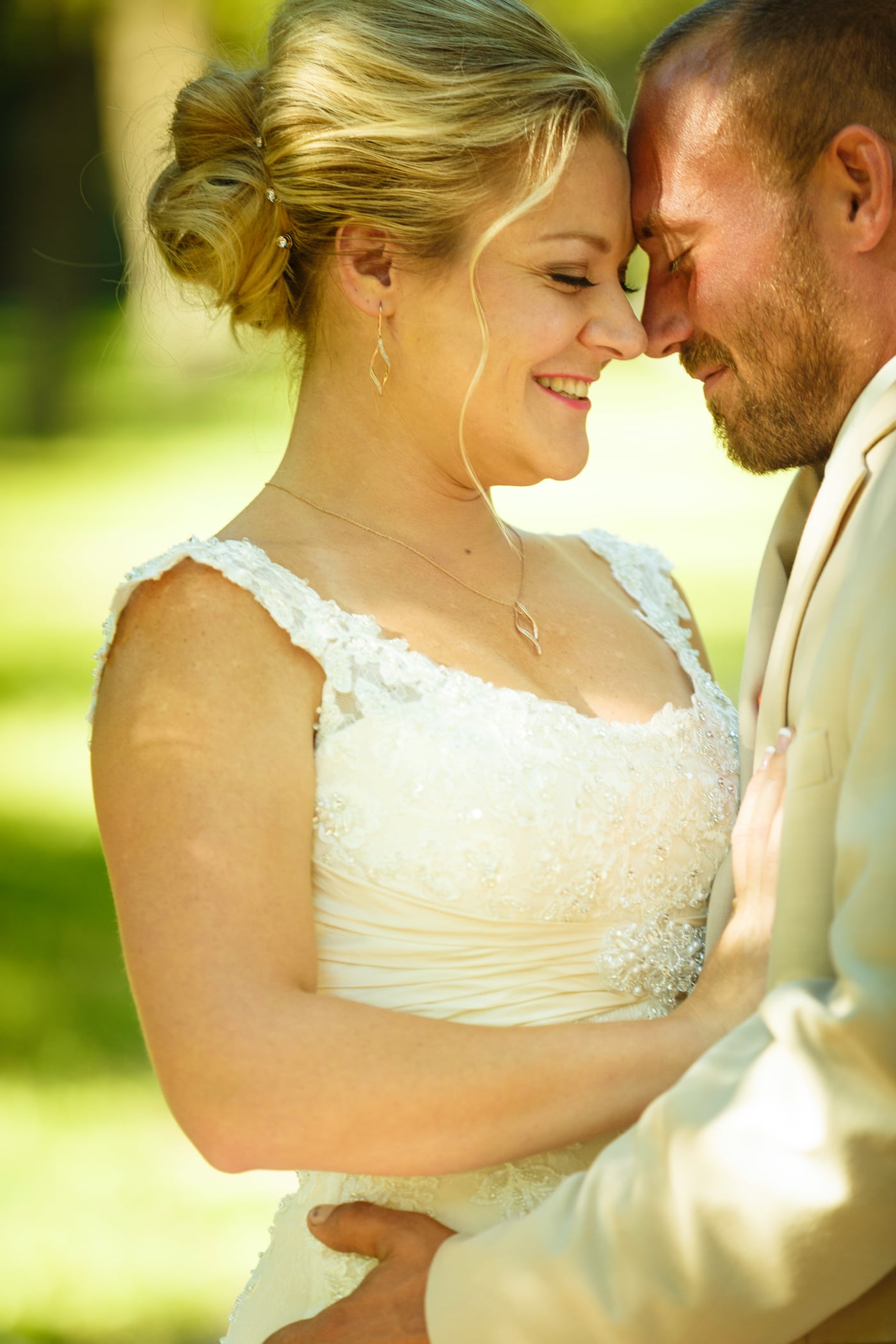Bride + groom forehead touch, warm.