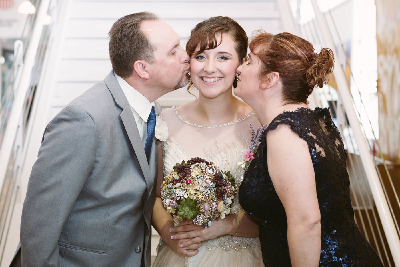 Parents kissing bride's cheeks, vintage.
