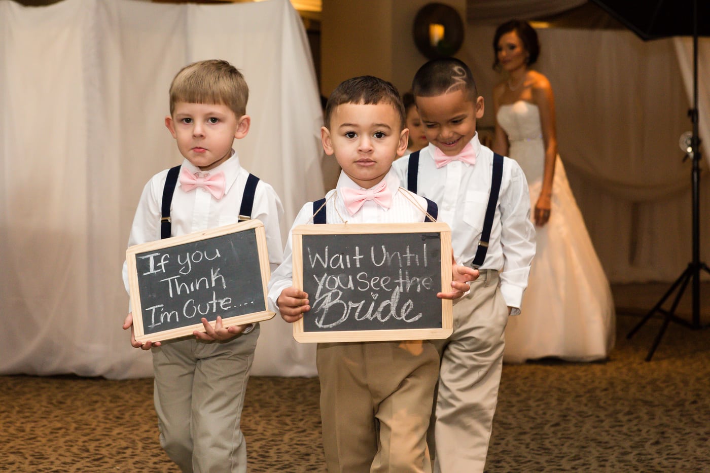 Ring bearers holding chalkboard signs, candid charm.