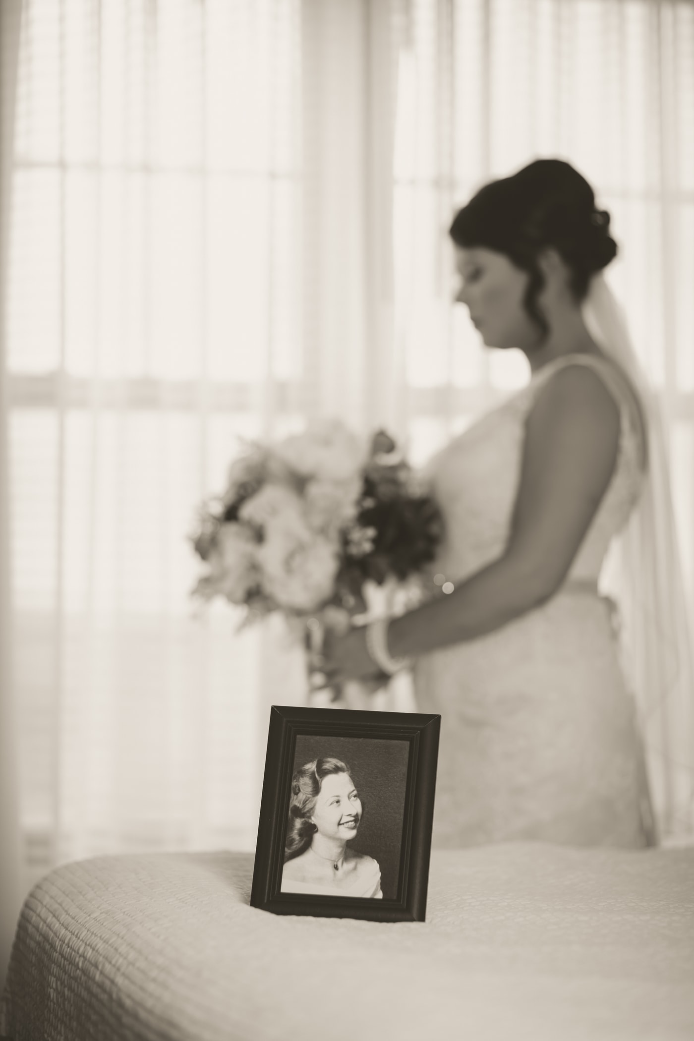 Bride holding framed family portrait.