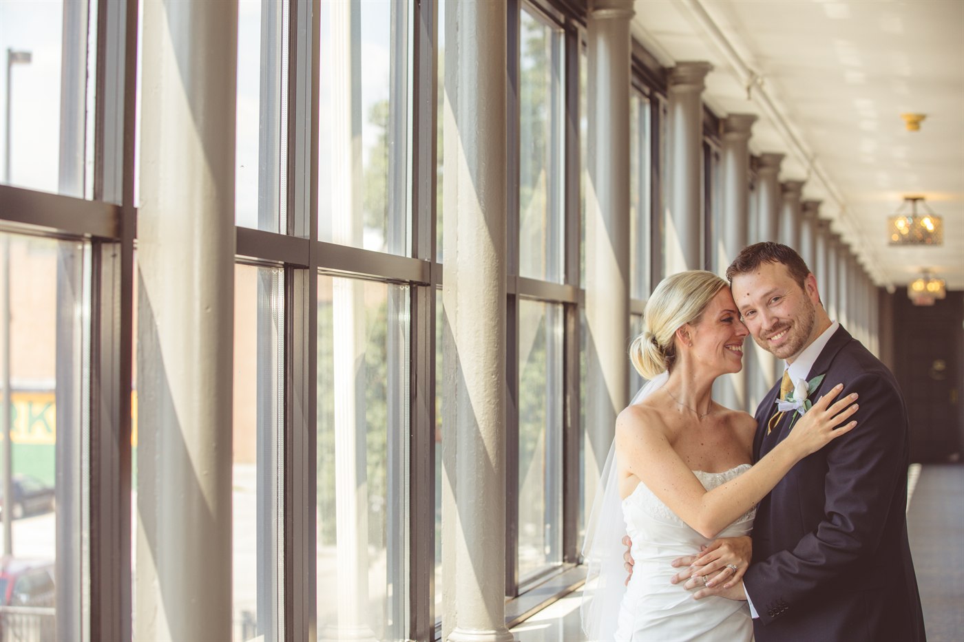 Wedding couple kiss by modern columns.