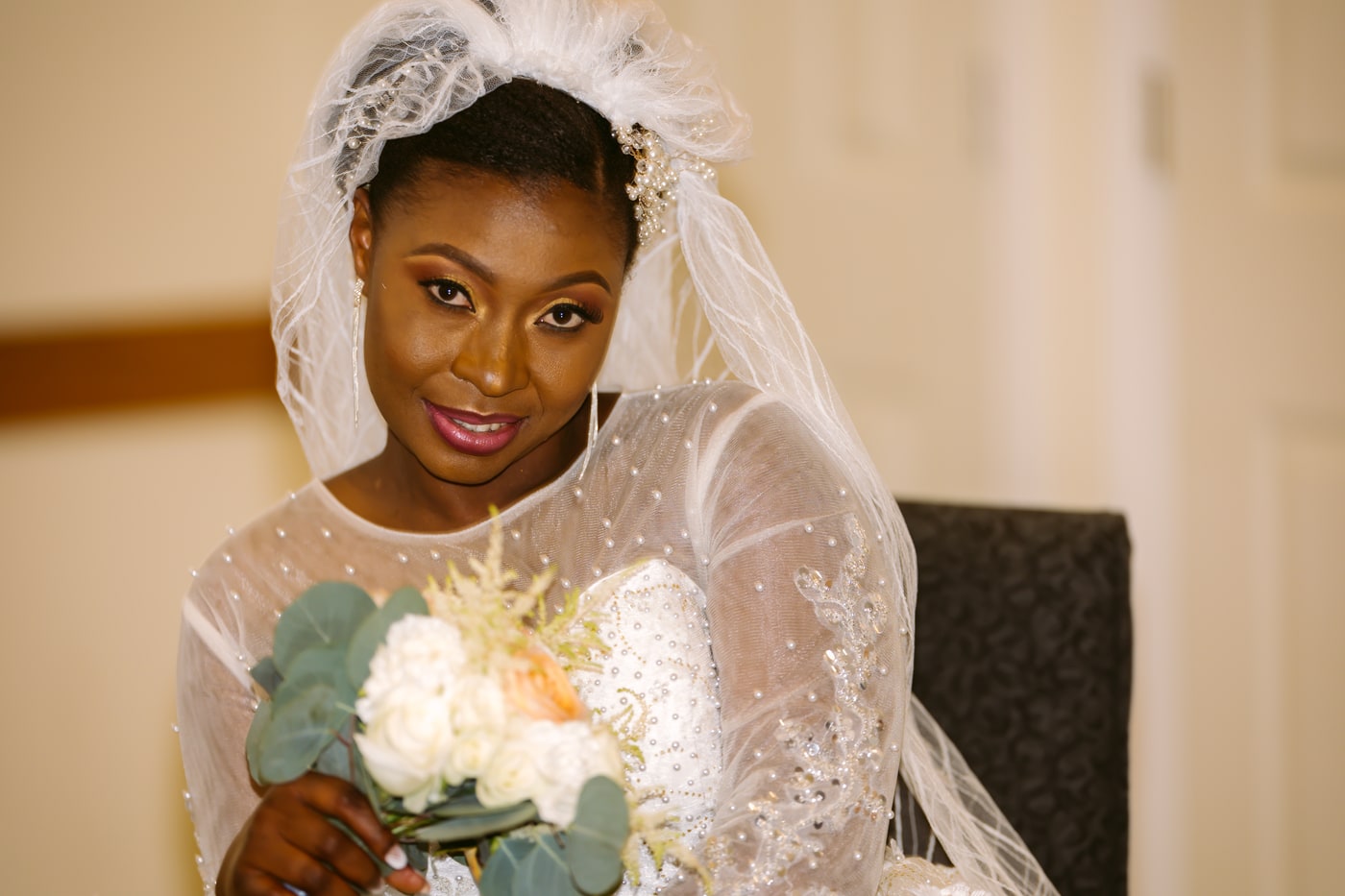 Bridal portrait with veil and warm indoor light.